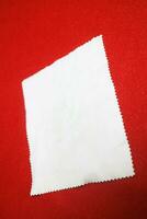 brightly colored cloth that serves to wipe glasses, on a red background photo