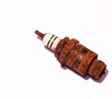 a rusty spark plug on a white surface photo