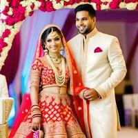 AI generated Indian groom dressed in white Sherwani and red hat with stunning bride in red lehenga stand and hold each hands walking outside photo