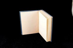 a book open on a black surface with a white object photo