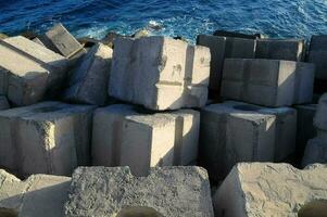 a pile of concrete blocks sitting on the beach photo