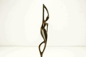 a bronze sculpture of a woman holding a stick photo