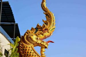 a golden dragon statue with a blue sky in the background photo