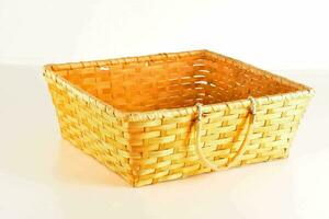 a wicker basket with handles on a white surface photo