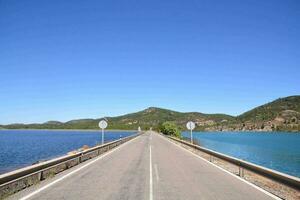 un largo puente con un la carretera en el lado foto