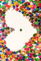 a heart shaped confetti is surrounded by many different colors photo