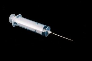 a syringe with a needle on a black background photo