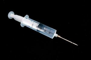 a syringe with a needle on a black background photo