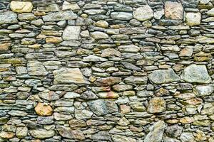 a stone wall with many different types of rocks photo