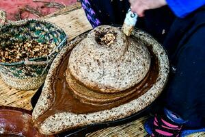 a woman is pouring a bowl of nuts into a pot photo