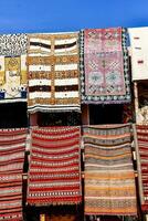 a row of colorful rugs on display in front of a building photo