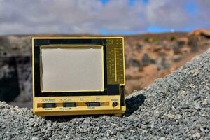 an old television sits on top of a rock photo