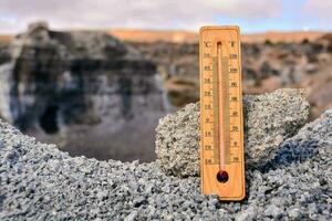 a thermometer is placed on a rock in the middle of a desert photo