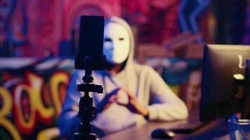 mascarado hacker ameaçador para não Pare inundação servidores e lançamento ddos ataque em local na rede Internet fazer isto batida a menos que dele demandas estão não conheceu, filmando chantagem vídeo dentro subterrâneo bunker video