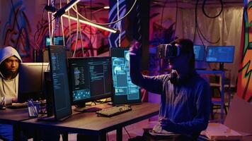 Hacker using virtual reality goggles technology to steal sensitive data by taking advantage of security breaches. Cybercriminal in hidden base using VR headset to gain unauthorized access to systems video