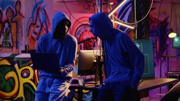 New member in hacking group receiving guidance from experienced rogue programmer acting as his mentor in underground hideout. Master hacker teaches script kiddie how to develop malware video