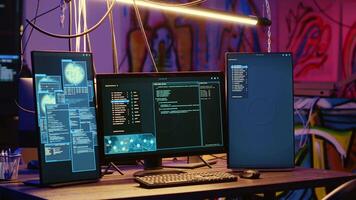 High tech computer systems running malicious code in messy empty criminals hideaway. Virus script running on PC monitors in empty neon lit warehouse used by hackers to commit illegal activities video