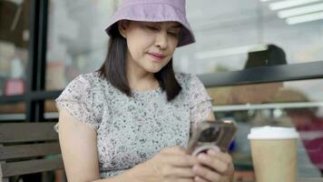 A woman drinks coffee and uses a smartphone in the kitchen while getting ready for work. video