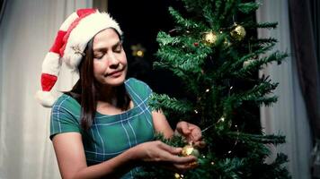 Weihnachten Baum mit rot Glas Bälle beim Zuhause auf Weihnachten Vorabend jung Frau schafft ein heiter Stimmung video