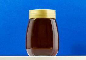 a jar of honey on a blue background photo