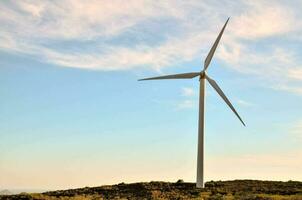 un viento turbina es mostrado en un ladera foto