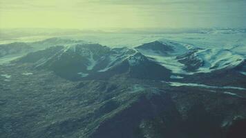 large snow patch left over on the volcanic rock field of a mountain in summer video