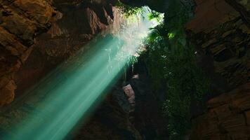 A mesmerizing green light shining through the entrance of a mystical cave video