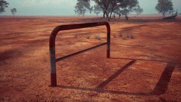 un' rustico rosso sporco campo con un' affascinante recinto e alberi nel il sfondo video