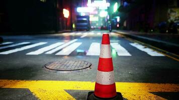 A red and white traffic cone sitting on the side of a road video