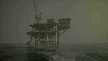 An oil rig standing tall in the middle of the vast ocean video