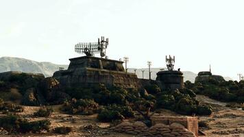 A desert landscape with rocks and trees surrounding a military base war bunker video