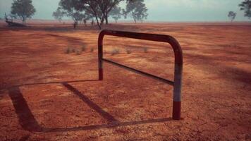 een rustiek rood aarde veld- met een charmant hek en bomen in de achtergrond video