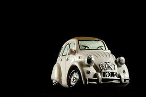a white toy car is shown against a black background photo