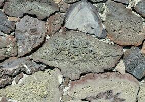 a close up of a wall with rocks and stones photo