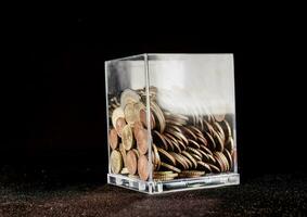 a clear glass container filled with coins photo