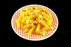 a plate of pasta on a checkered plate photo