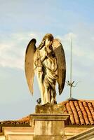 an angel statue on top of a building photo