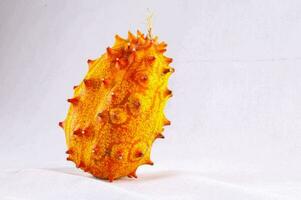 a yellow fruit with red spikes on it photo