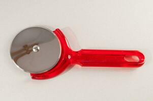 a red plastic pizza cutter photo