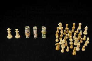 chess pieces and money on a black background photo