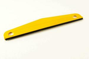 a yellow plastic blade on a white surface photo