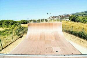 a skateboard ramp in a park with a hill in the background photo