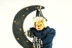 a wooden clown on a crescent moon photo