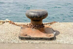 a rusty metal object is sitting on the edge of a dock photo