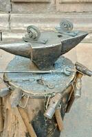 an old blacksmith's anvil with a hammer and other tools photo