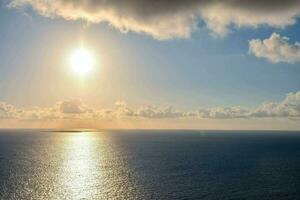 the sun is shining over the ocean photo