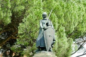 a statue of a man holding a sword and shield photo