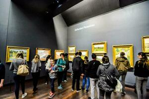 people looking at paintings in an art museum photo