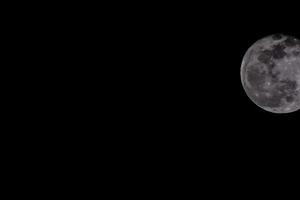 the moon is seen in the dark sky photo