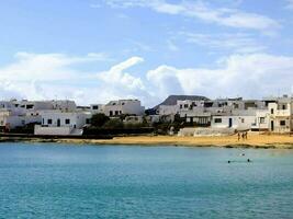 un playa con blanco casas y azul agua foto